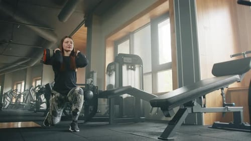 Woman Exercising with Weight in Gym