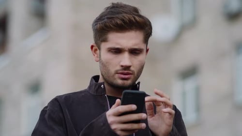 Young man using smartphone in city setting