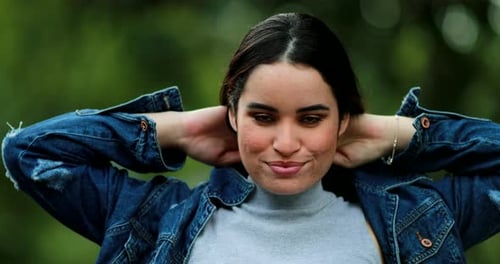 Attractive Brunette Woman Styling Hair Outdoors in Natural Light