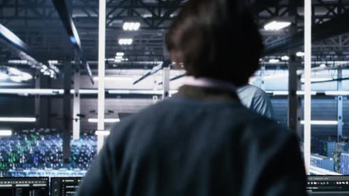 Data Center Technician Using Laptop to Monitor Neural Network AI LLM