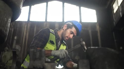 Engineer is working at machine part factory.