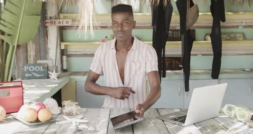 Man Using Tablet at Beachfront Shop