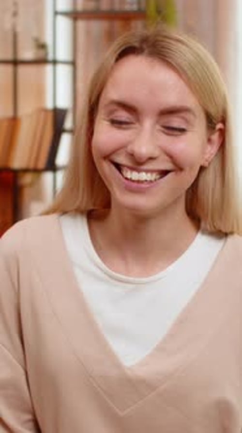 Smiling blonde woman in casual clothing indoors