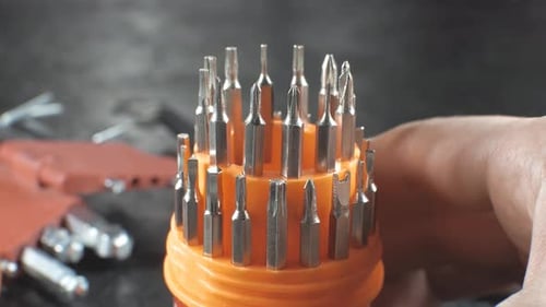 Man is choosing Different types of screwdrivers and hex keys