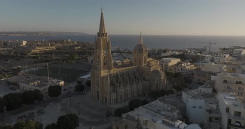 Aerial view of historic church overlooking coast, Malta.