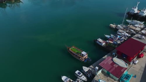 Aerial Video of a Secluded Port With Small Boats and White Yachts Surrounded By Stunning Blue Waters