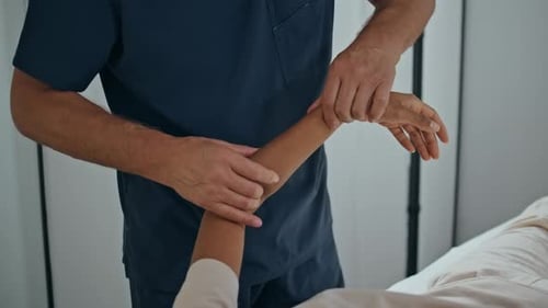 Healthcare Provider Working With Patient's Arm