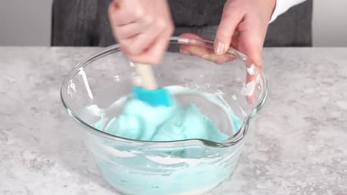 Mixing in Blue Food Coloring Into the Buttercream Frosting