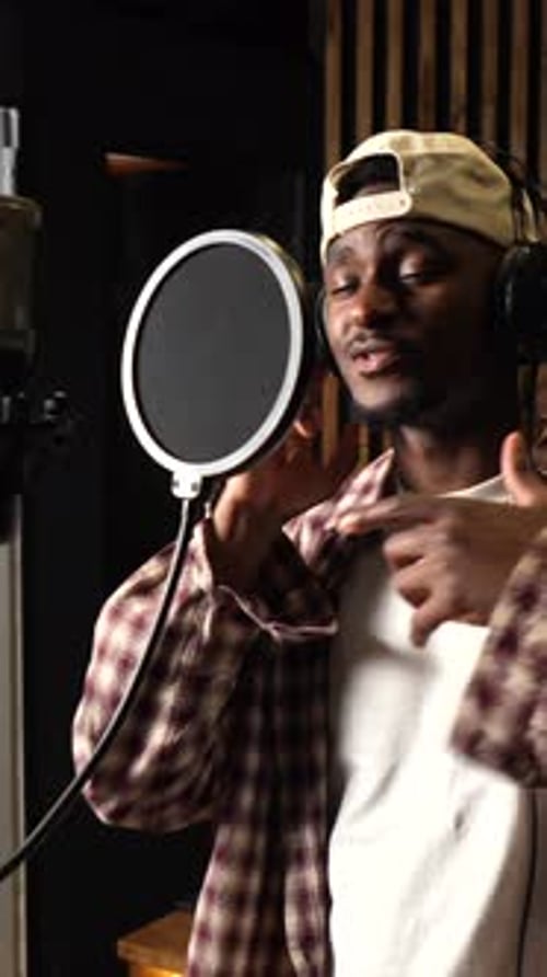 Young african american singer recording new album in professional studio