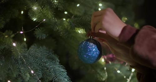 Decorating Christmas Tree with Blue Glittery Ornament