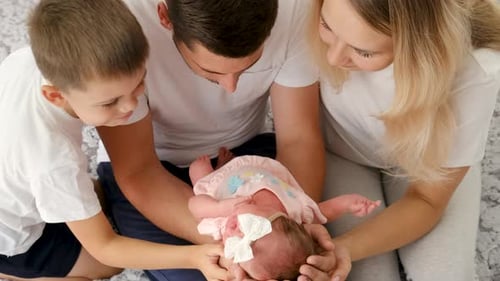Family Admires Adorable Newborn Baby at Home