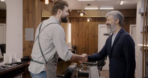 Client and Barber Shaking Hands Talking Preparing for Grooming in Barbershop