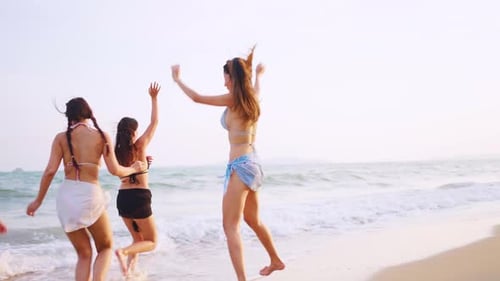 Close up of women friends walking on the beach during summer together.