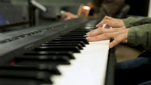 Female hands playing the piano in the studio