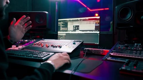 Nahaufnahme des Aufnahmeraums im Dunkeln mit Neonbeleuchtung im Studio, mit dem der Toningenieur arbeitet