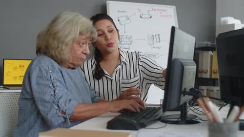 Woman Tutoring Senior on Computer Skills