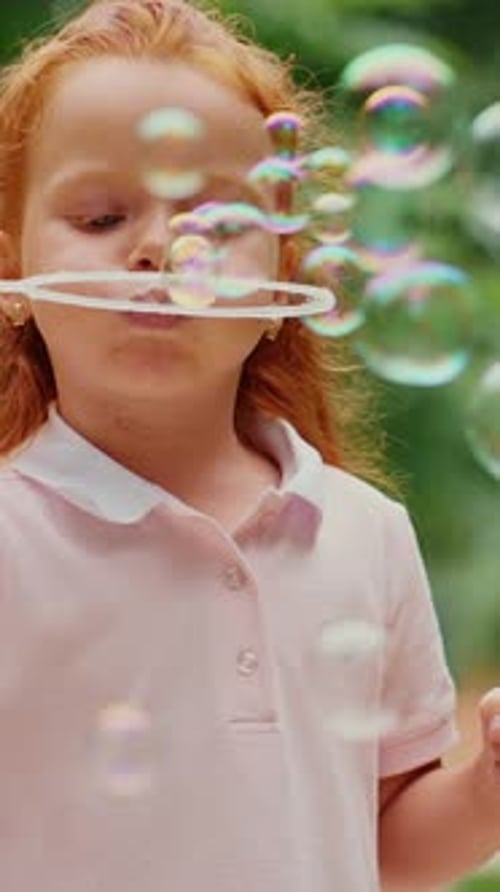 Child Blowing Bubbles in Sunny Park Surrounded By Trees
