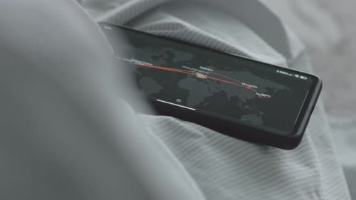 Smartphone Displaying World Map Data on Bedding