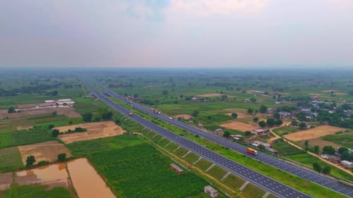 Modern roads stretch across the landscape, connecting large area of farmland below.
