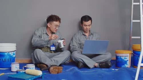Worker Eating Lunch and Discussing Plan of House Renovation with His Colleague