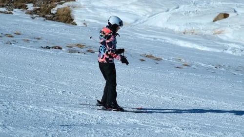 Skier Gliding Down a Snowy Mountain on a Sunny Day