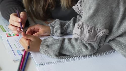 Child Doing Homework with Adult Assistance