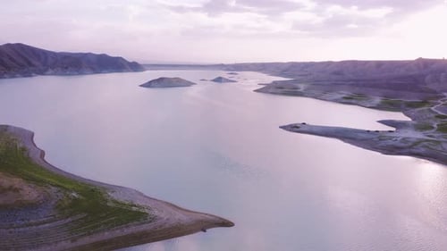 Breathtaking aerial view on a beautiful lake surrounded by mountains lit by a summer sunset sky in A