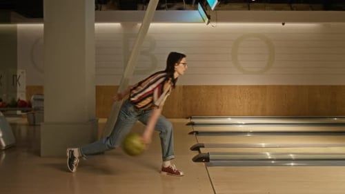 Woman Throwing Bowling Ball on Lane during Leisure Activity