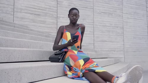 Stylish Woman in Colorful Dress Using Smartphone