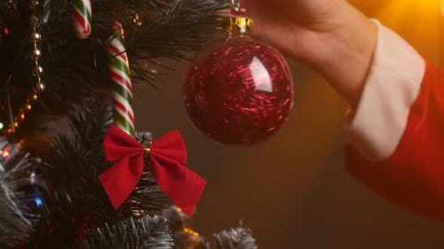 Woman Decorates a Christmas Tree with Ornament
