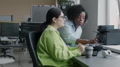 Two Diverse Female Programmers Having Conversation at Workplace
