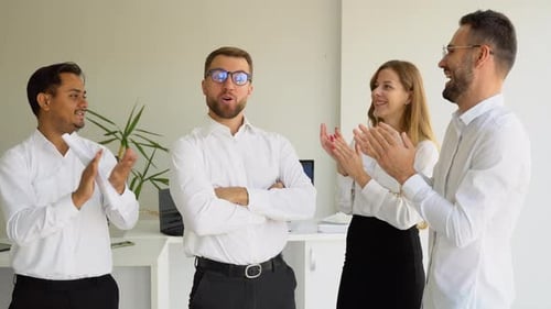Team Celebrates Man in Modern Office