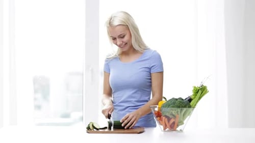 Smiling Woman Cuts Vegetables in Bright Home Kitchen