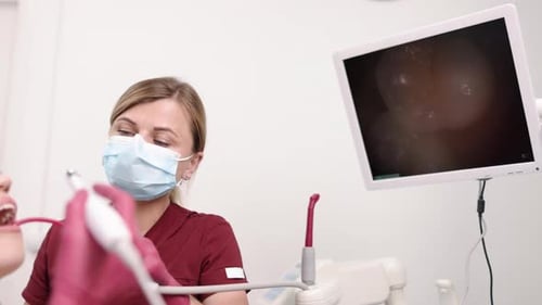 Dentist Performs Oral Exam Using Modern Equipment
