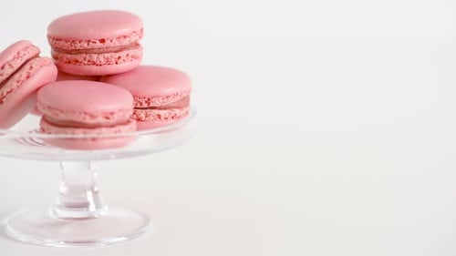 Pink macarons stacked deliciously on glass confectionery stand
