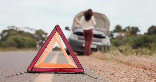 Woman, car breakdown and reflector triangle with phone call, stress or emergency on road