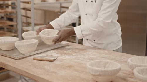 Baker Preparing Dough for Rising on Tray Rack