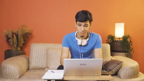 L'homme qui regarde un ordinateur portable n'est pas motivé et s'ennuie.