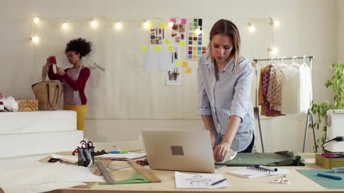 Young women designers planning a startup business in bright studio workroom