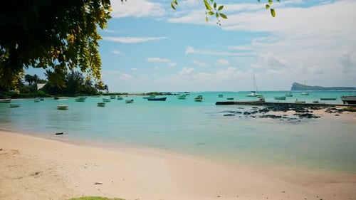 Tropical empty beach. Small wooden fishing boats anchored close to the shore. Unspoiled exotic beach
