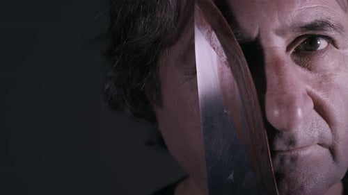 Menacing Man Stares Intensely Behind a Deadly Knife