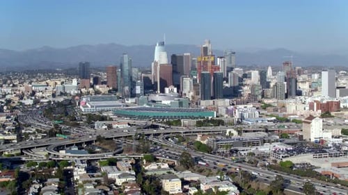 Downtown Los Angeles skyline awaits as drone soars through the night