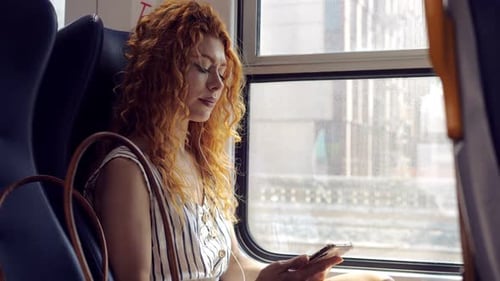 Woman Using Mobile Phone on Train Journey