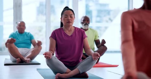 Group of Adults Meditating Together on Exercise Mats