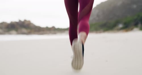 An unrecognizable sportswoman running on the beach