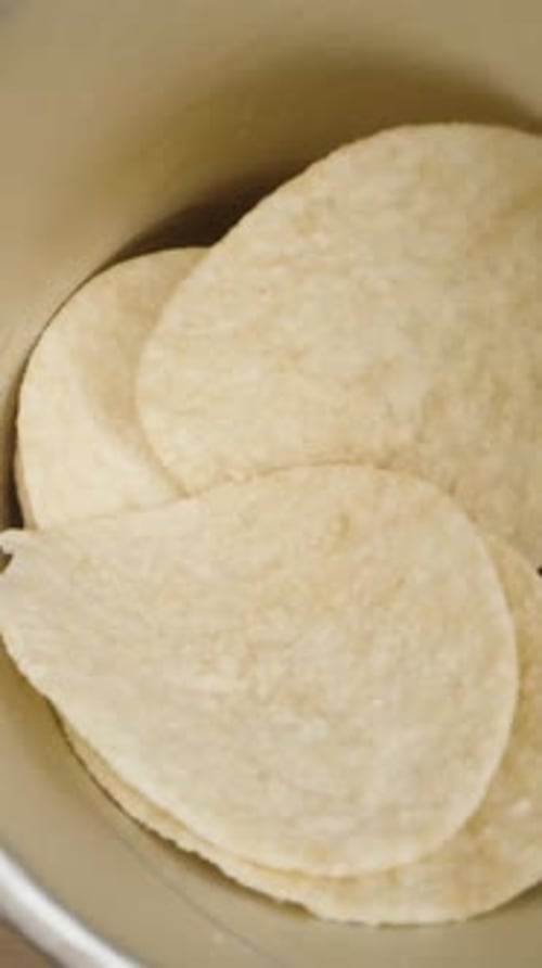 Vertical video. Top-down movement into the can with corn chips as I take them. Dolly slider.