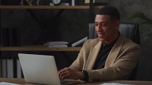 Man Works On Laptop in Office Setting