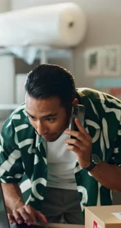 Young Man on Cellphone at Workplace with Package