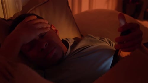 Schlafstörungen Dunkelhäutiger Kerl störte Angst beim Versuch, sich mit Telefon im Bett auszuruhen