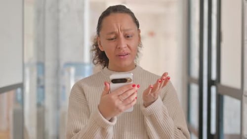 Portrait of Multiracial Woman Shocked by Loss on Phone
